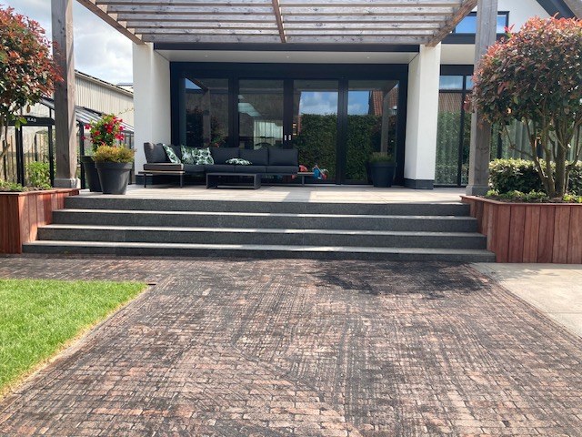 Modern terras met strakke bestrating bij de woning