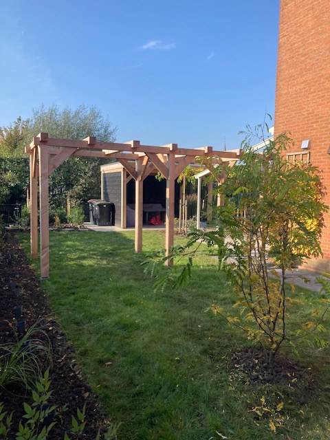 Tuin met pergola en gevarieerde beplanting